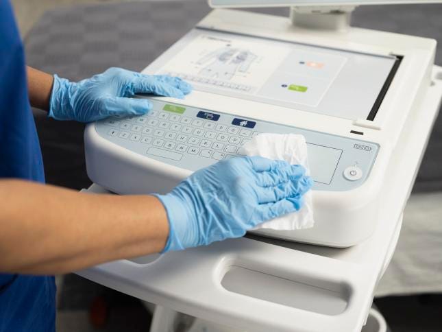 Healthcare worker wiping the keyboard of an ELI 380 ECG