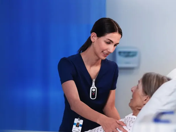 A healthcare worker wearing a Voalte Linq device