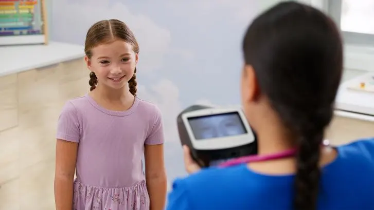 Pediatric patient getting vision checked by caregiver