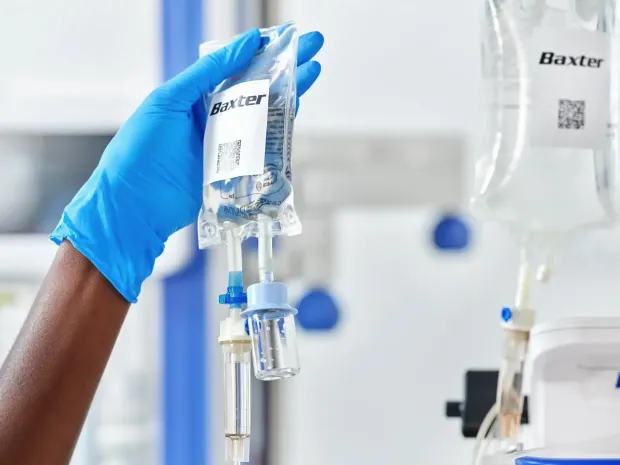 Healthcare professional hanging an IV bag on a stand