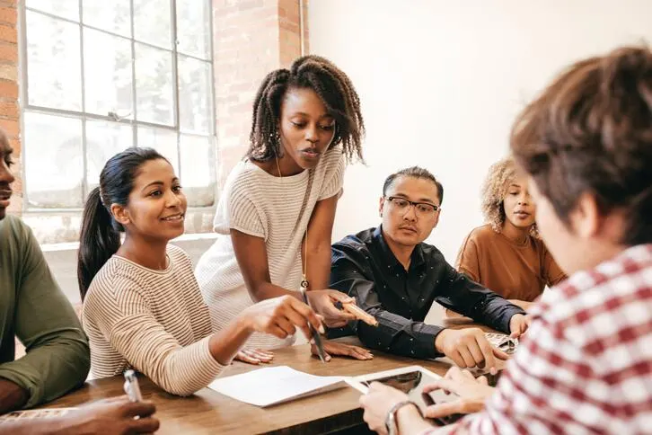A group of people have a discussion in a business setting.