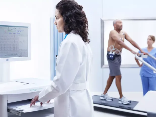 A clinician reviewing the Cardio Server Stress Server while a patient exercises