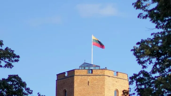 The lithuanian flag flying at the top of a building