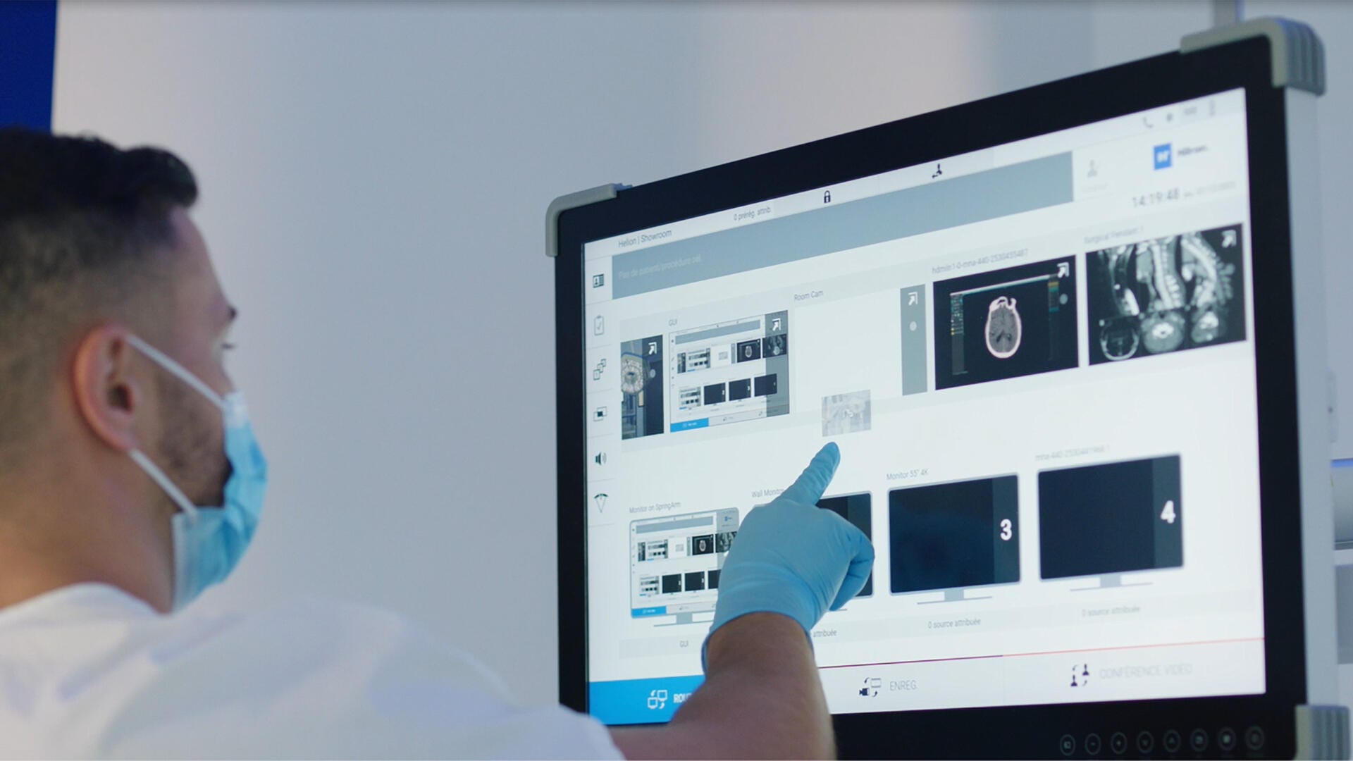 A hand pressing the touchscreen of the Helion monitor