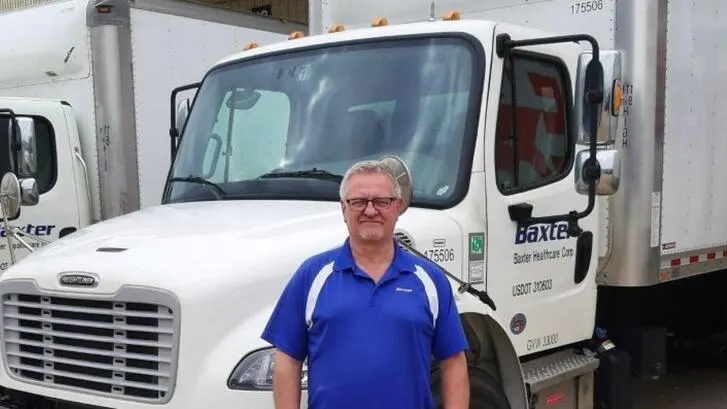 Christopher Nelson poses in front of a Baxter delivery truck