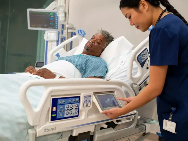 Healthcare worker adjusts settings on a Progress Plus Bed