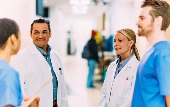 A group of healthcare workers chatting in a hospital corridor