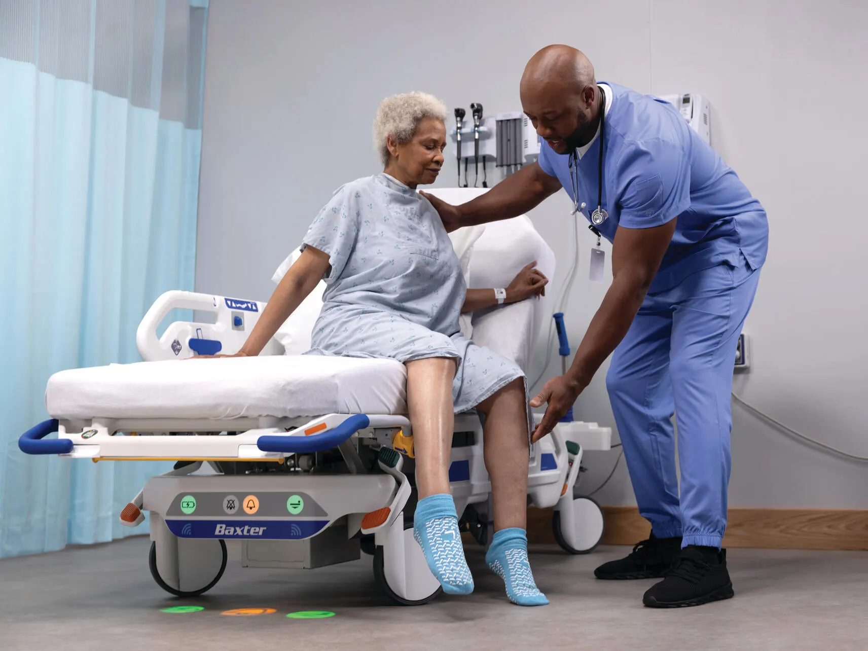 Healthcare worker helps a patient up from a Dynamo Series Stretcher