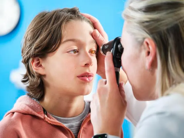 Physician uses the PanOptic Plus opthalmoscope to look into the eye of a pediatric patient