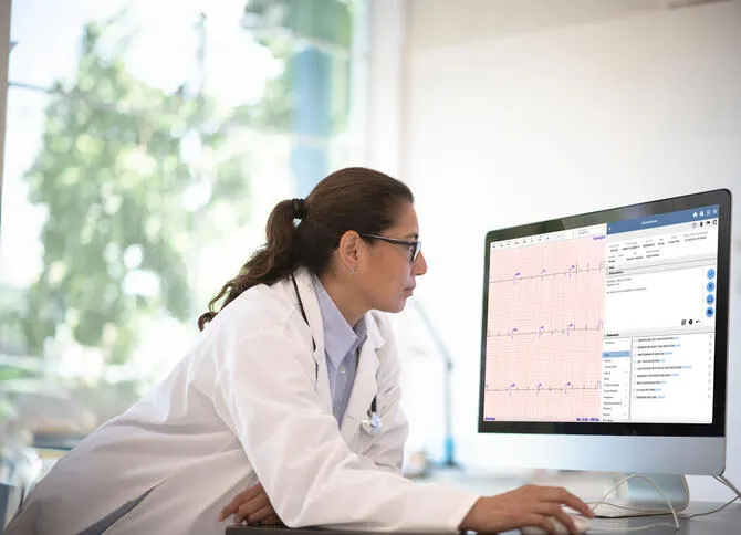 Physician looks at an ECG readout on a computer monitor