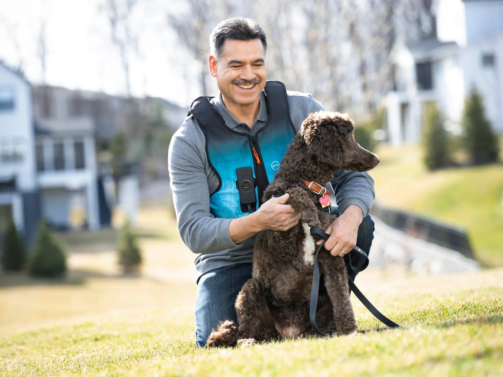 Man wearing the Monarch respiratory vest holding his dog outside
