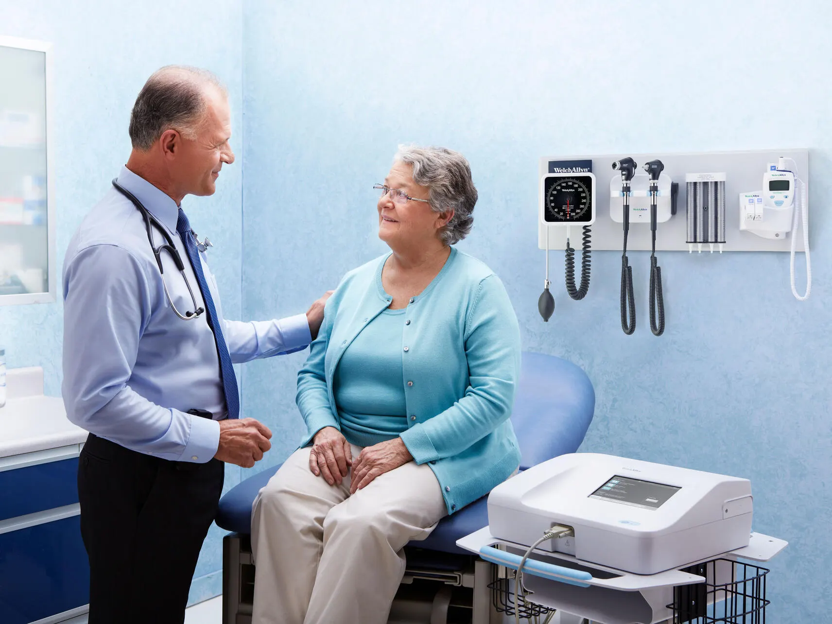 Healthcare professional talking to patient while holding her arm