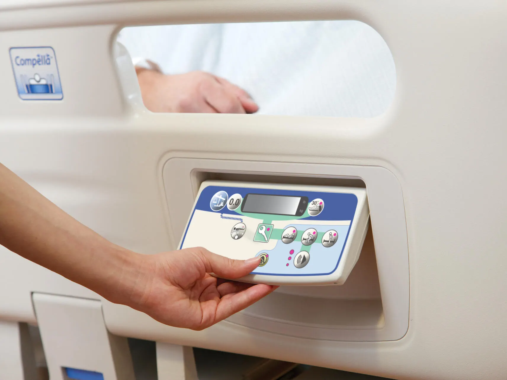 Technician adjusting the fold-out controls on the Compella bariatric bed