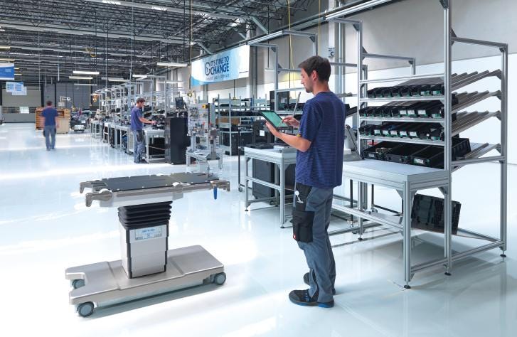 A manufacturing worker inspects a surgical table base