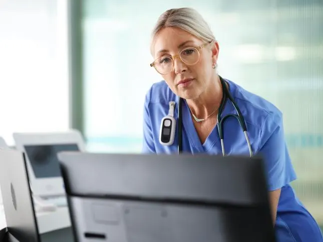 Nurse examining an EMR at a Nurse Station