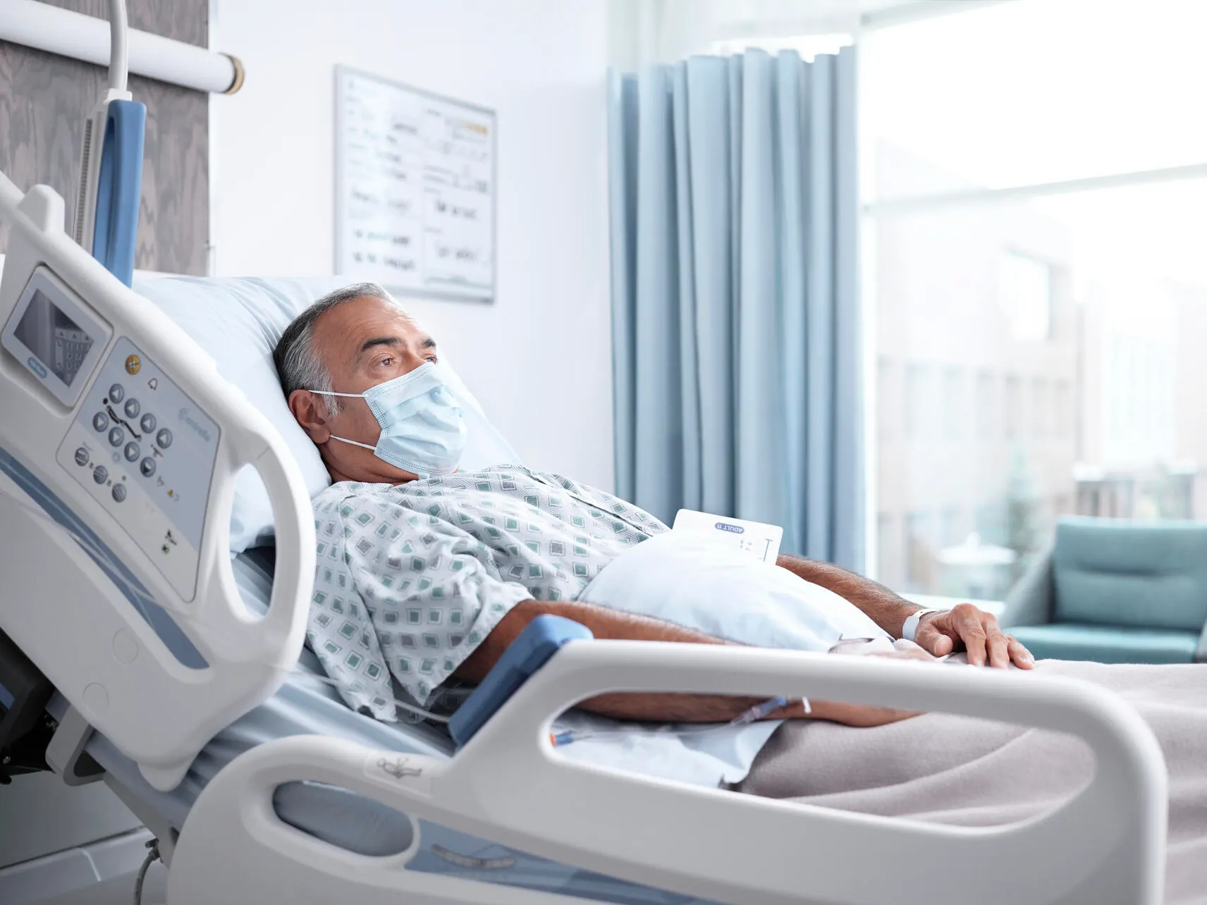An elderly patient lays in a hospital bed