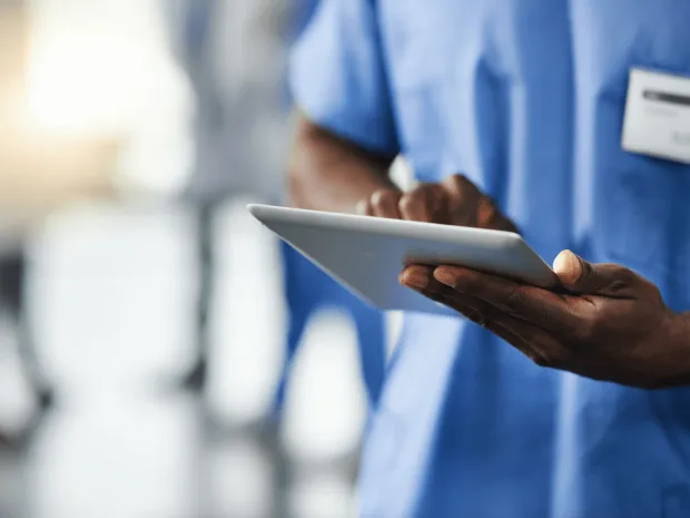 Healthcare worker typing on a tablet