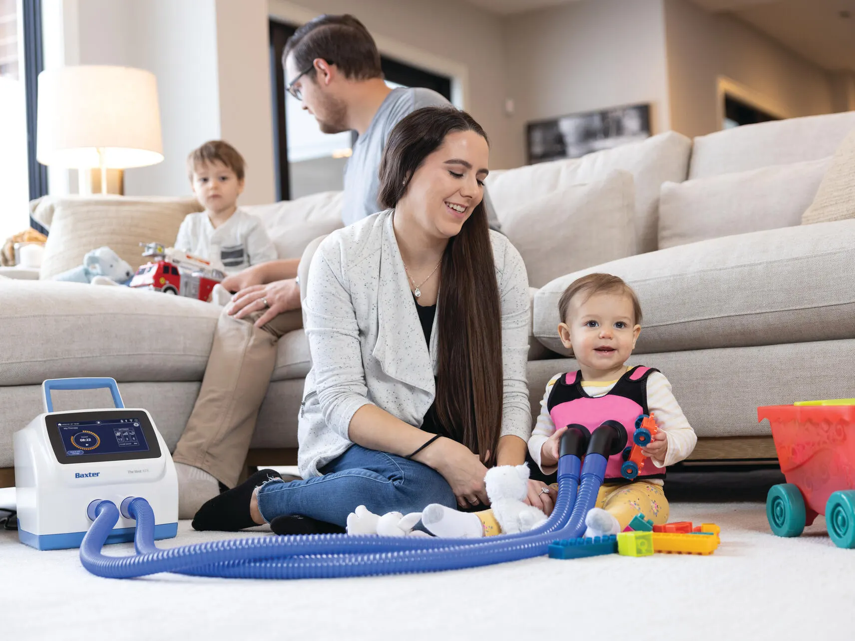 9 month old child playing on the floor with their parent while wearing the Vest APX