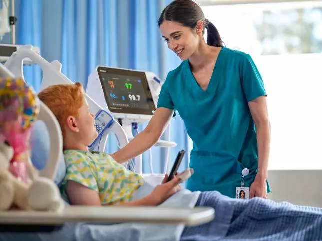 Nurse attending to pediatric patient in bed