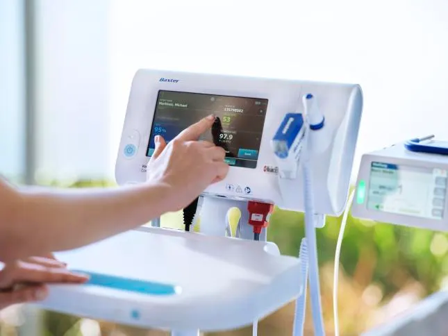 Hand using the touchscreen of a Connex Spot Monitor