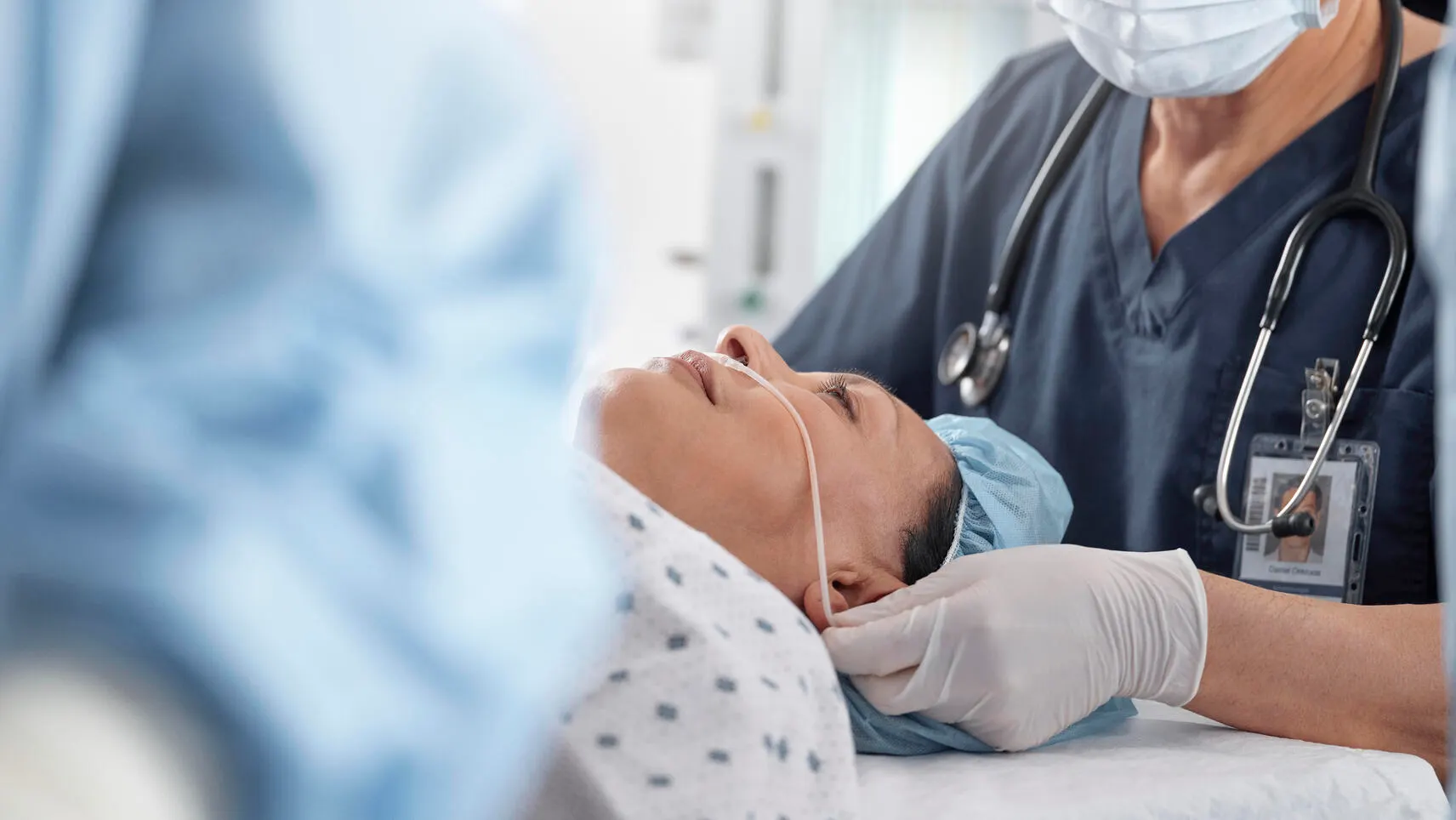 Healthcare worker adjusting a nasal cannula during surgery.