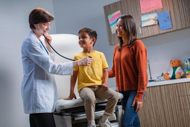 Pediatric child being seen by caregiver in a primary care office