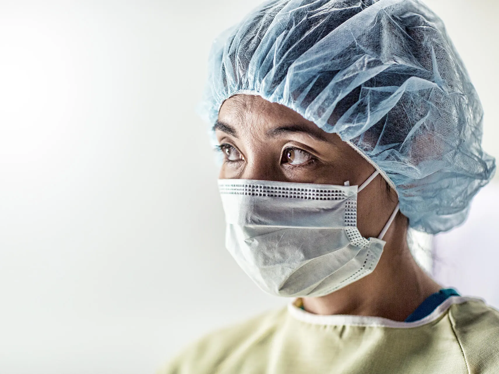 Healthcare professional in scrubs, hairnet and surgical mask