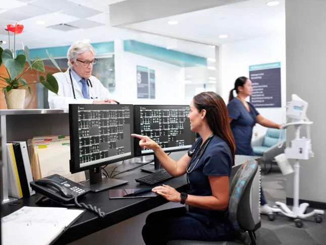 Healthcare professionals monitoring the vitals of patients at a nursing station