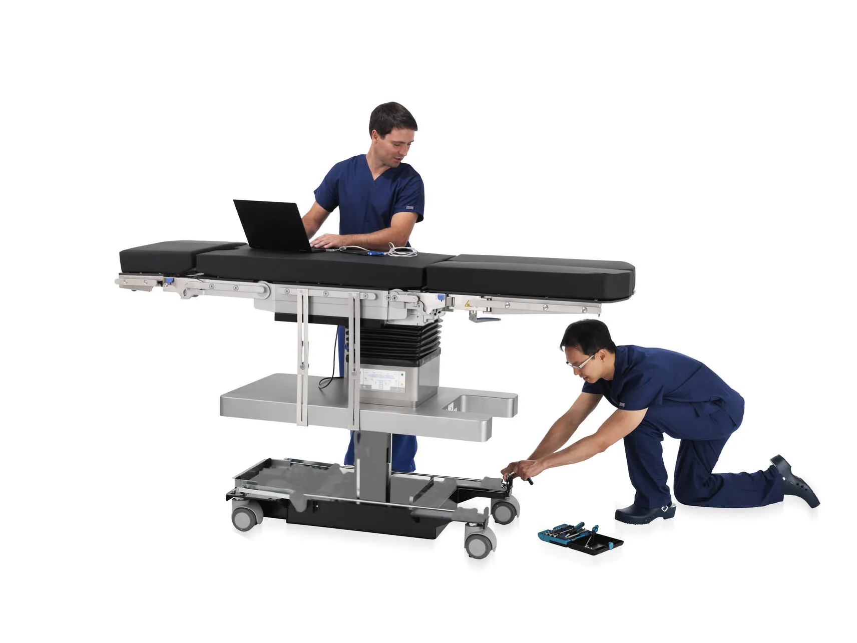 Support technicians perform maintenance on a surgical table