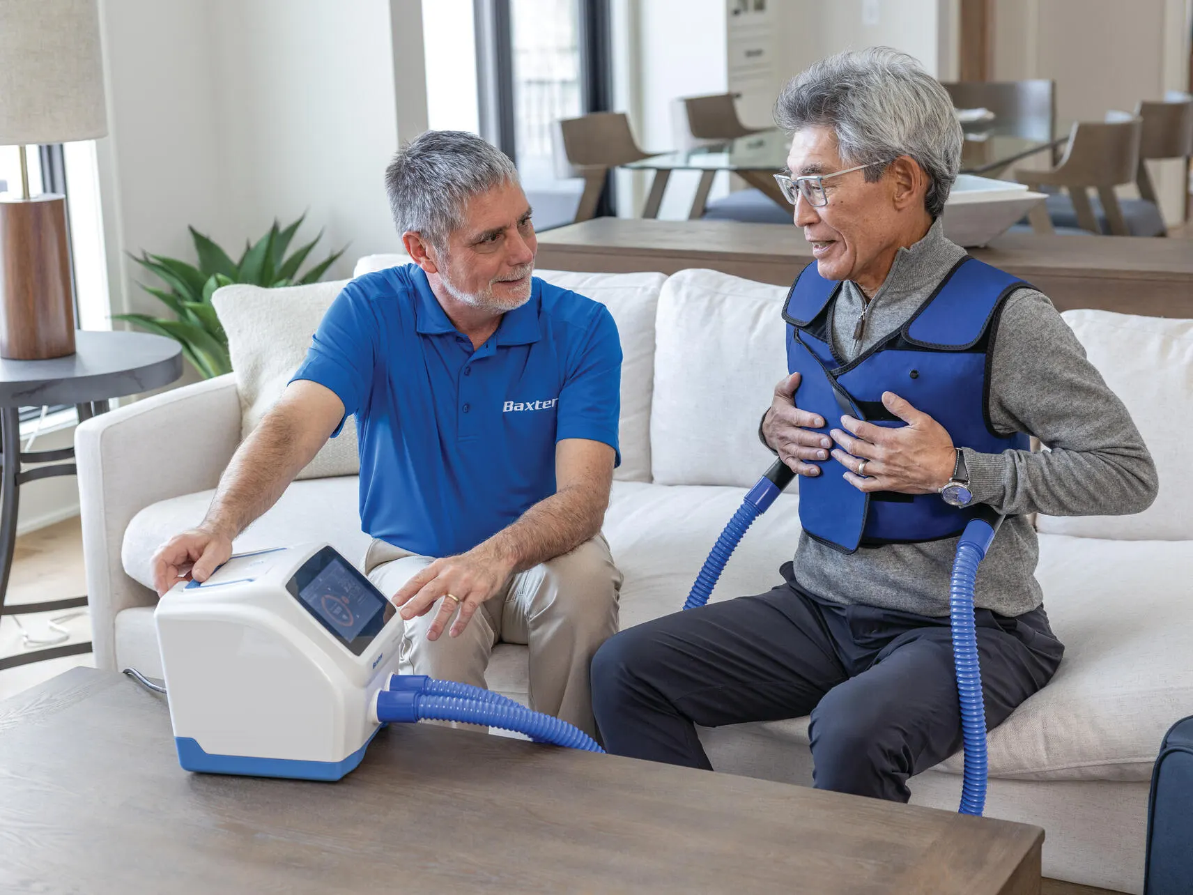 The Vest APX on a patient, being shown its interface, in his living room