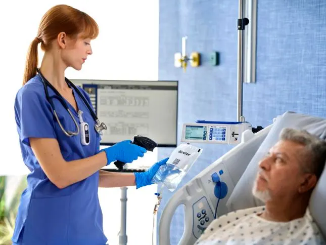 Nurse scans premix medication bag while patient looks on