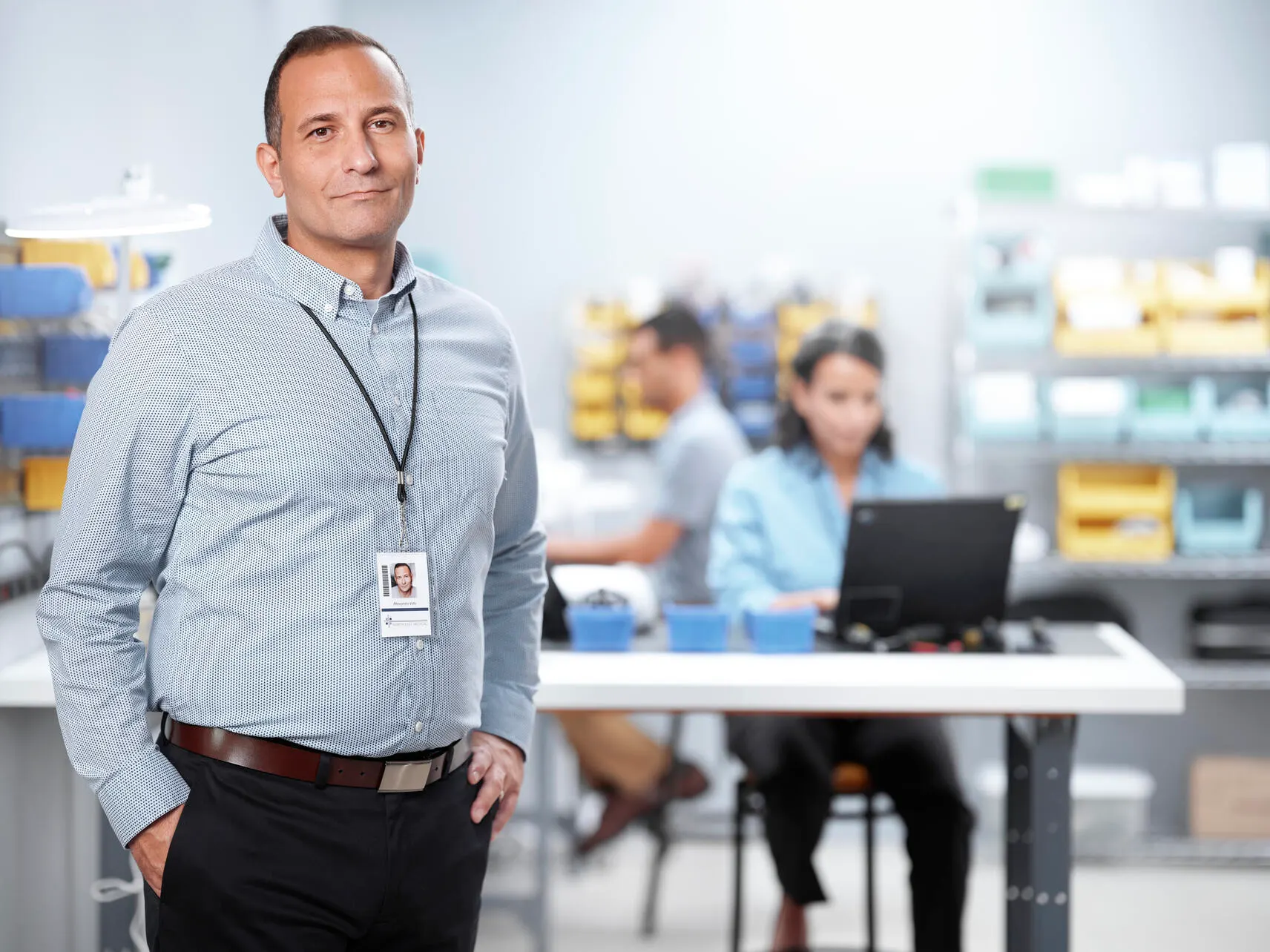 A biomed technician smiles at the camera in a technician's office