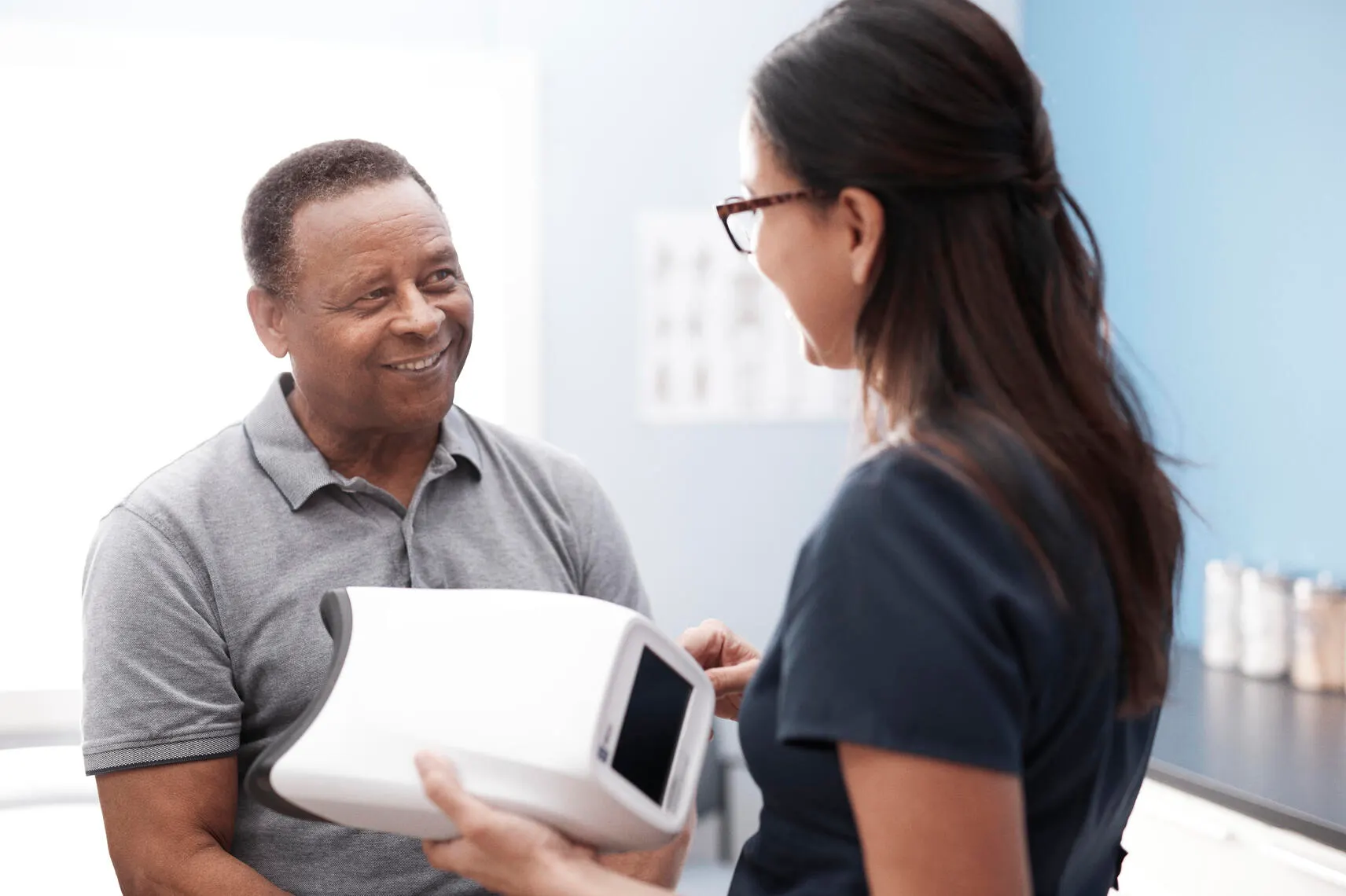 Physician holding Welch Allyn RetinaVue 700 Imager and talking to patient