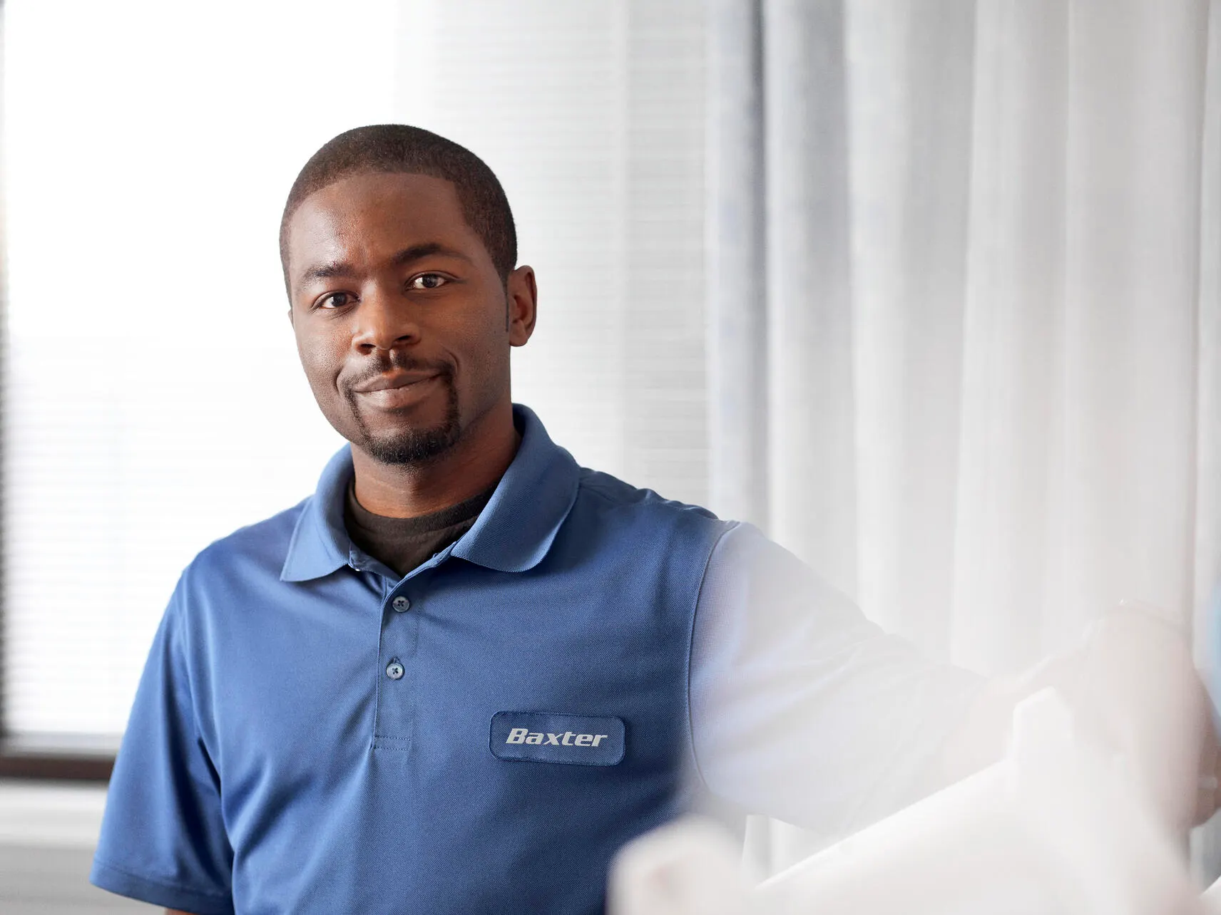 A Baxer service techician smiles at the camera