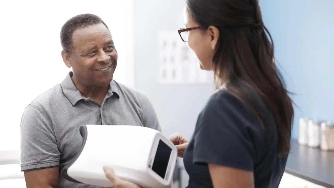 A nurse and patient smile using a RetinaVue device