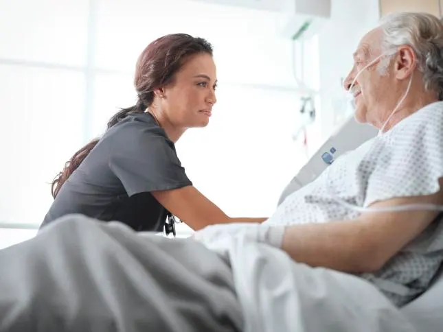 Caregiver assisting a patient in bed