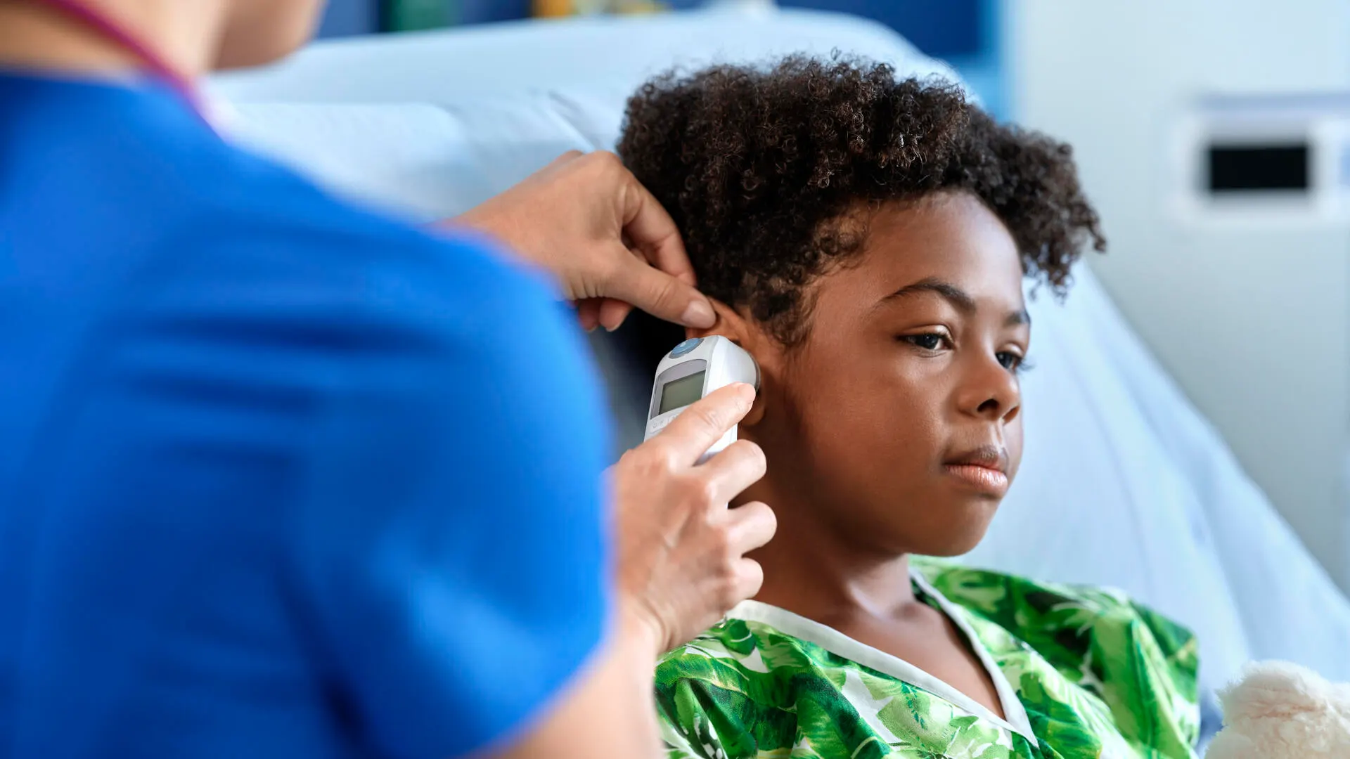 Nurse checking ear of pediatric patient