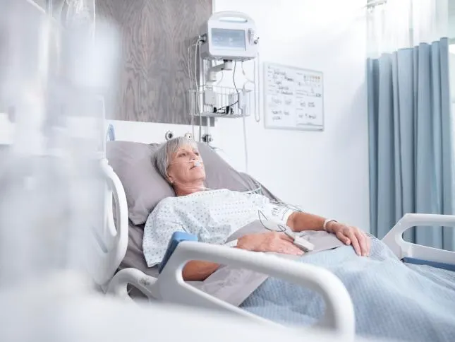 Patient lying in a hospital bad below a Connex Vital Signs Monitor