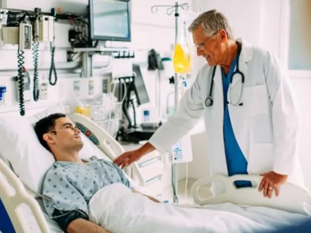 Physician comforts a patient in a hospital bed