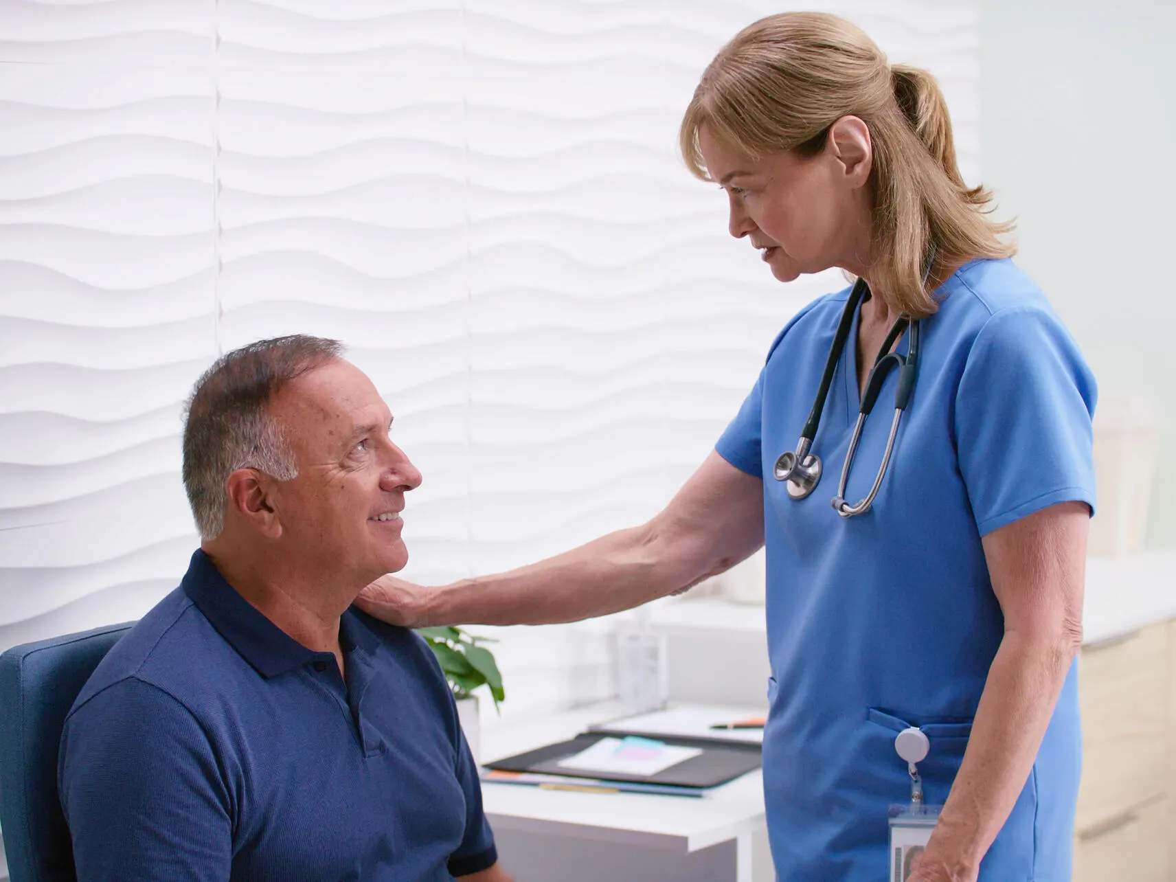 Healthcare worker comforts a smiling man