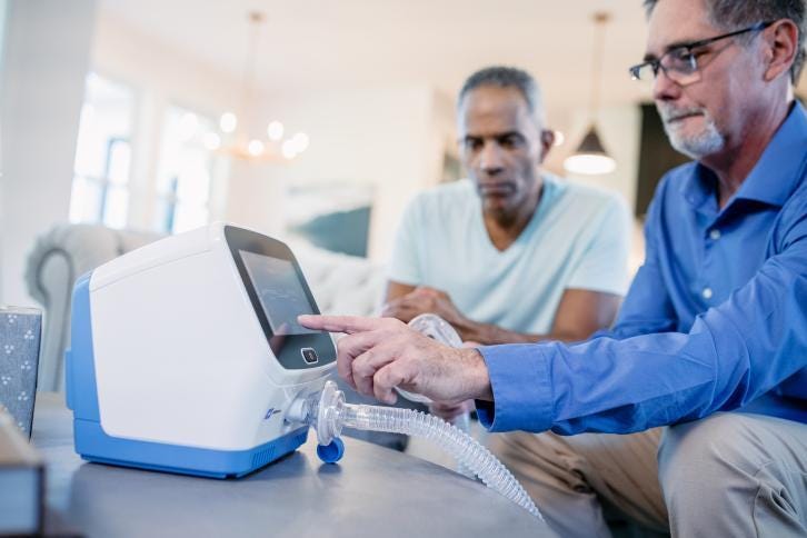 Technician helping patient with Synclara in living room
