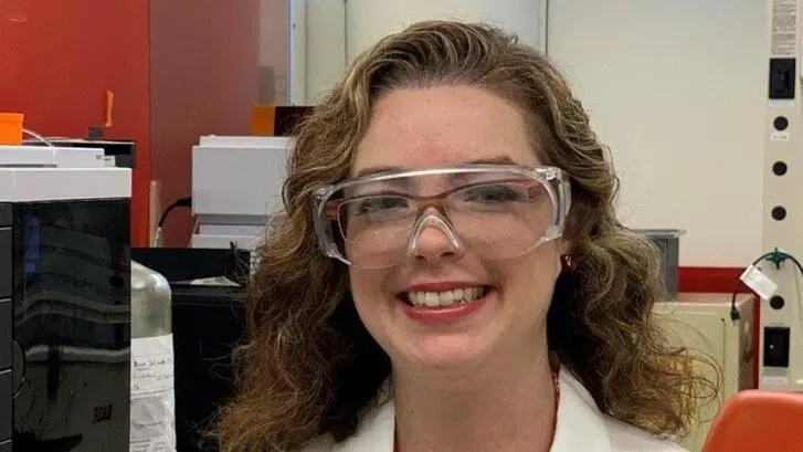 Sarah Lee wears safety goggles and smiles at the camera