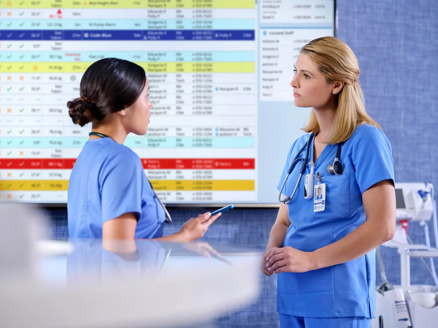 Nurses at a nursing station discuss patient status