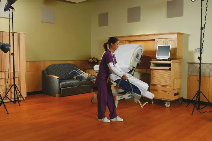 A healthcare professional carrying a lift off foot section of the Affinity 4 birthing bed