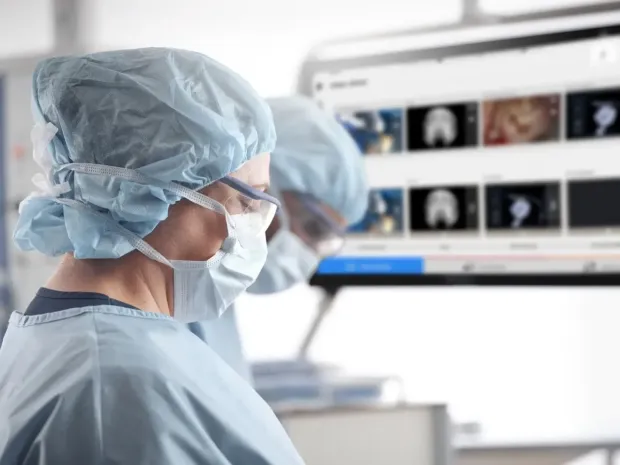 Surgeons look at a screen with surgery image