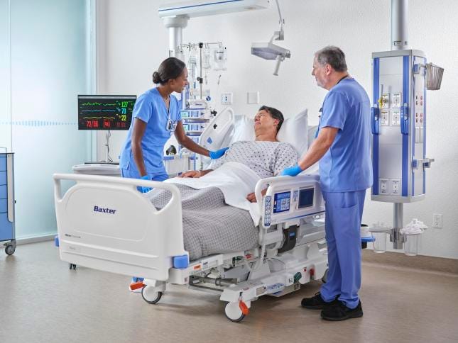 patient in hospital bed with two nursers