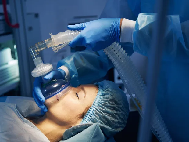 An anesthetist applies a mask to a surgical patient