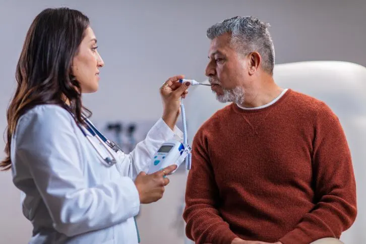 Healthcare Professional takes a patient's temperature with a SureTemp plus thermometer