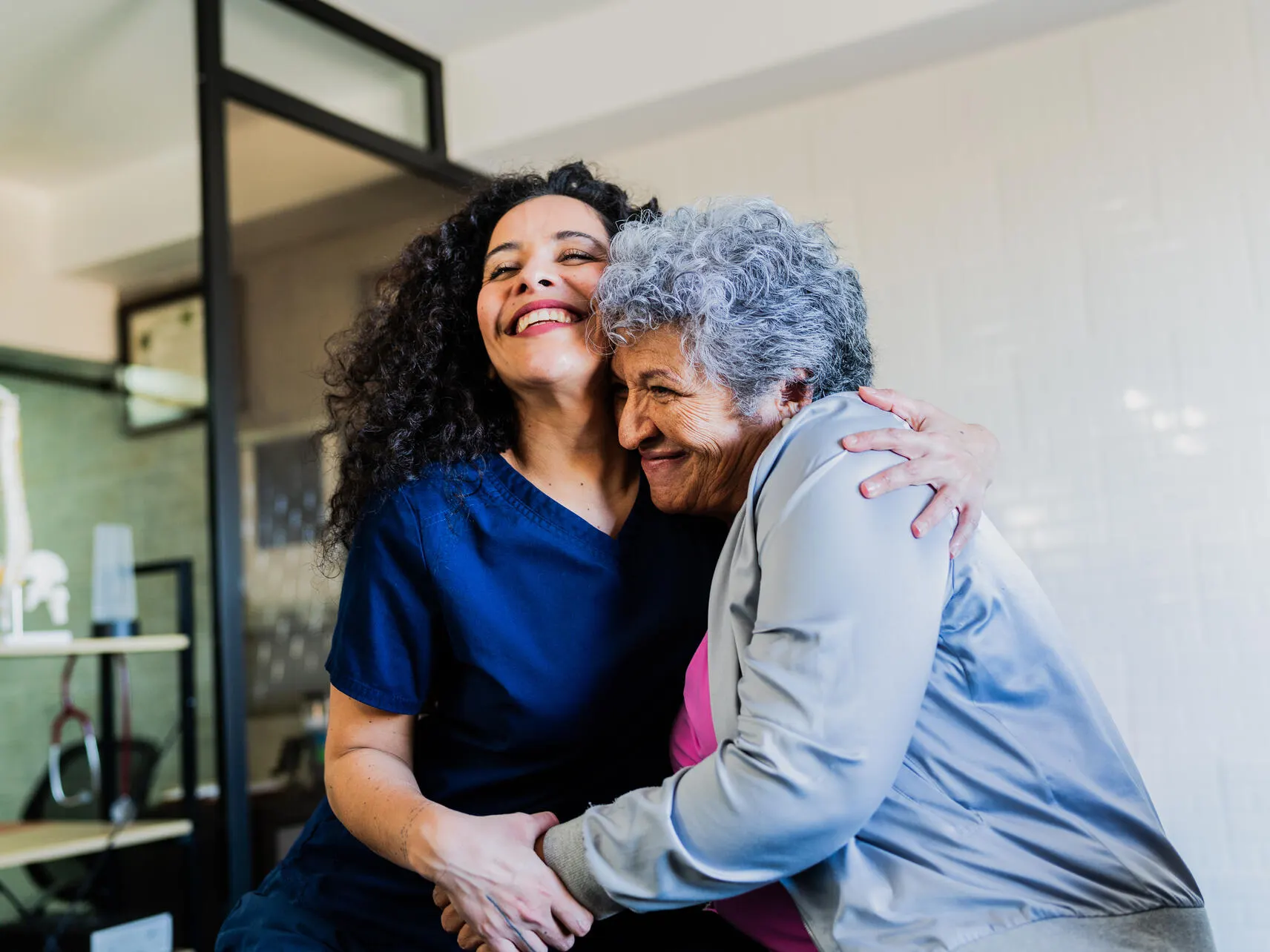 Healthcare worker hugs an elderly patient