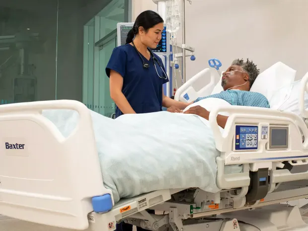 Healthcare worker comforts a patient in a progressa plus hospital bed